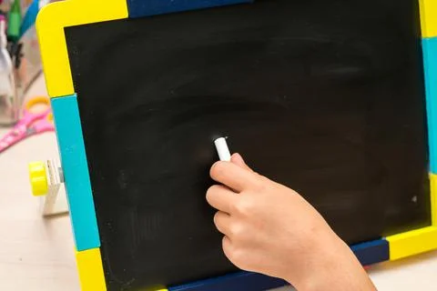 Left hand write on school desk on black background Stock Photos