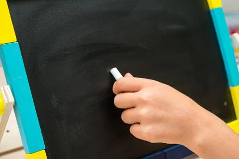 Left hand write on school desk on black background Stock Photos