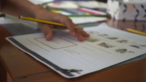 Left handed boy is doing his homework. Kid writes with his left hand. Stock-Footage 220056484