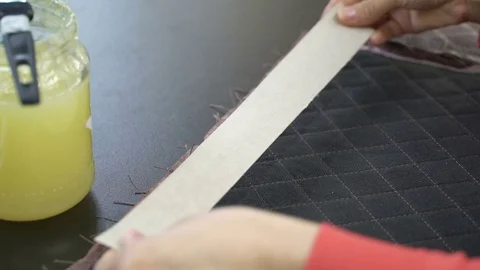 Left-hander accurately paste cardboard on the back of the quilted leather Stock Footage 79284030