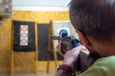 Left-hander in a shooting range shoots a gun Stock Photos