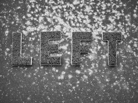 Left lettering in black on black rusty metal surface Foto stock