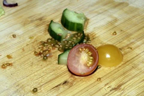 Left over salad from dinner chopped cucumber tomato onion food waste on cho.. Stock Photos