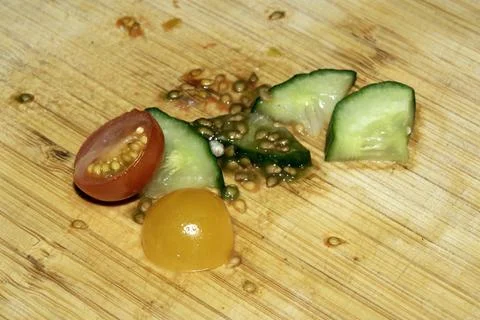 Left over salad from dinner chopped cucumber tomato onion food waste on cho.. Stock Photos