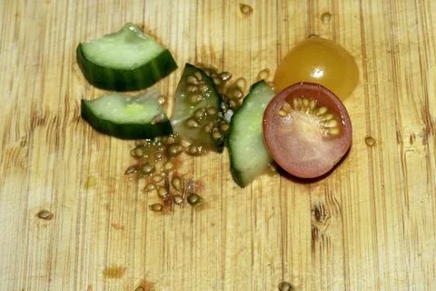 Left over salad from dinner chopped cucumber tomato onion food waste on cho.. Stock Photos