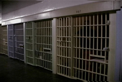 Left pan along an empty prison corridor lined with cells Stock Footage 86919965