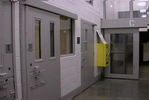 Left pan of prison entry corridor with locked metal doors Stock Footage 86920079
