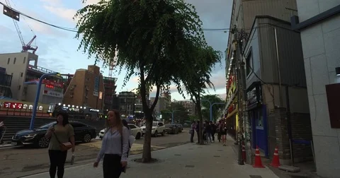 Left pan shot of pedestrians strolling in the evening Stock Footage 76500901