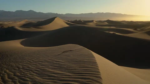 Left panning shot of a large dune field in the glow of early morning. Stock Footage 154973027