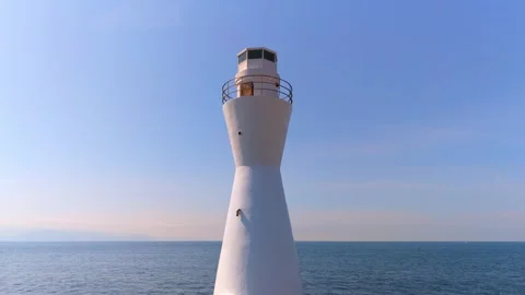 Left panning shot of a white lighthouse and Pacific Ocean Stock Footage 334679731