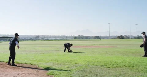 Left player gesturing start male baseball team tossing fielding grounder with Stock Footage 336783778