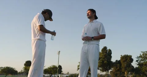Left player in white kit sipping water sparking juggling ball with diverse male Vídeos de archivo 344253166