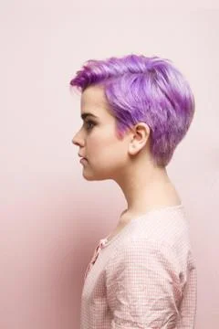 Left profile of a violet-short-haired woman in pink pastel. Stock Photos