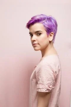 Left profile of a violet-short-haired woman in pink pastel. Stock Photos
