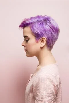 Left profile of a violet-short-haired woman in pink pastel. Stock Photos
