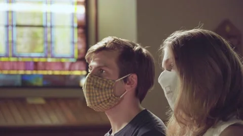 Left profile of young white couple social distancing in church Stock Footage 133096055