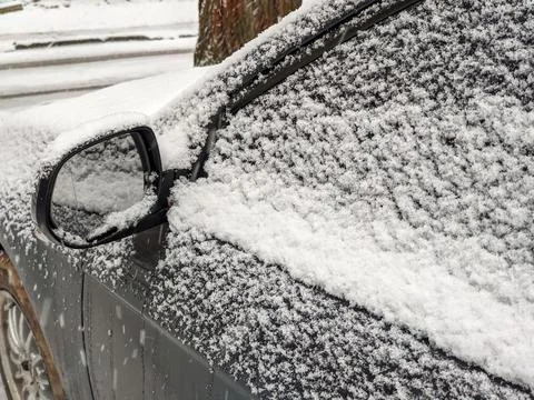 Left rear view mirror and side window of the car covered with snow Stock Photos