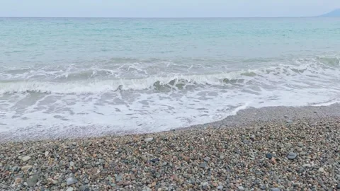 Left to right aerial of small waves on tropical pebble beach. Stock Footage 313526155