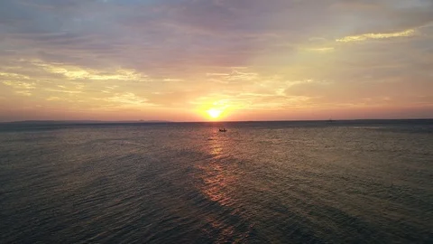 Left to right drone view of red sunset over ocean Stock Footage 89881812