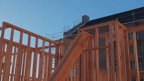 Left to right glide past wooden wall framing at active construction site Stock Footage 332823150