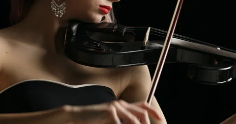 Left to right pan on black electrick violin played by blonde violinist Stock Footage 274864954