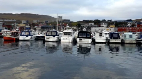 Left to right pan boats docking in small town pier colorful buildings background Stock Footage 92642453