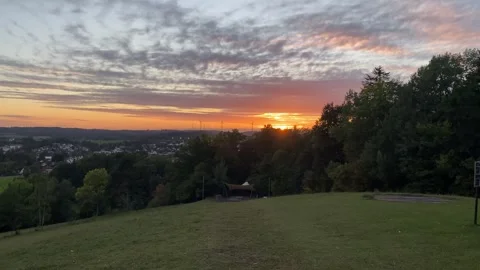 Left-to-Right Pan from City to Sunset with Wind Turbines on a Mountain in 4K Video stock 317582431