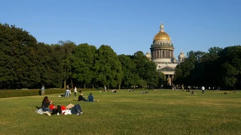Left to right pan crowd of people enjoying life in a park St Isaac's Cathedral Stock Footage 103288368