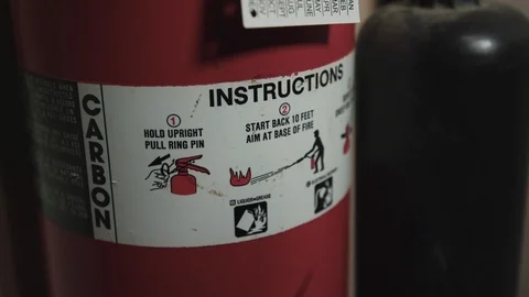 Left to right pan onto a fire extinguisher - safety instructions Video stock 89501366