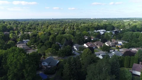 Left To Right Pan Flying Over Field Towards Lots Of Houses With Green Trees Stock Footage 121585997