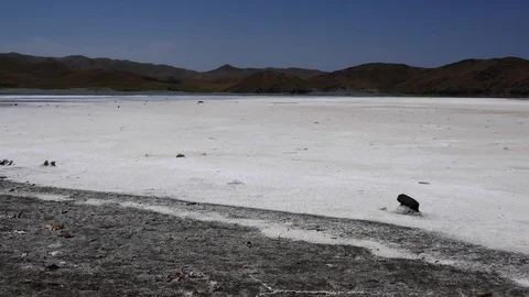 Left to right pan over a salty beach shore with mountains in the background Stock Footage 70356064