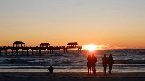 Left To Right Pan People On Beach And Pier Admiring Beautiful Romantic Sunse Stock Footage 127329536