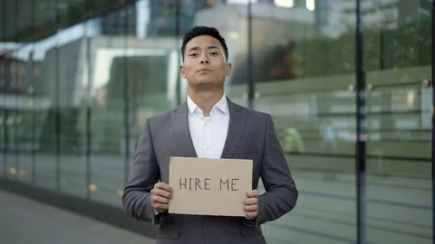 Left to right pan real time shot of a young Asian man in a suit standing on the Stock-Footage 124093923