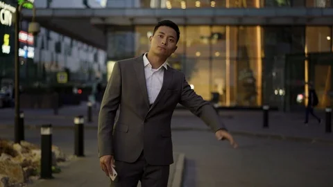 Left to right pan real time portrait shot of a young businessman catching a taxi 스톡 동영상 124095735
