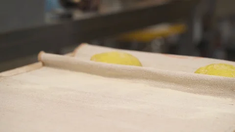 A left to right shot of a baker placing loafs of bread onto a covered with cloth Stock Footage 106255023