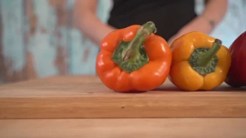 Left to right slide displaying three various colored bell peppers Stock Footage 131048930