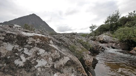 Left to Right Slow Shot from Rocks to Small Brook Flowing Stock-Footage 97361919
