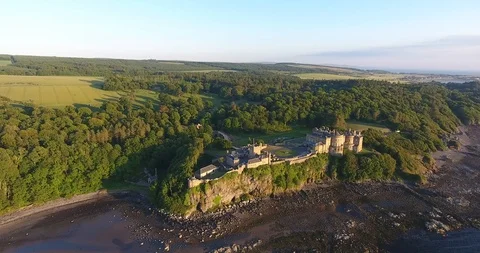 Left to Right Spin Drone Shot of a Scottish Castle Surrounded by a Small Forest 스톡 동영상 97380374