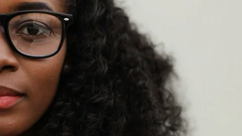 Left side of face of curly girl in glasses on white background. Young African Stock Footage 81839328