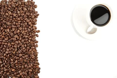Left side frame of scattered coffee beans with coffee cup on white background Stock Photos