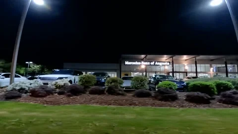 Left side pan Augusta Mercedes dealership at night Stock Footage 177673917