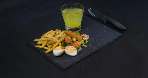 Left side view on a dish consisting of chicken breast breaded, French fries Stock Photos