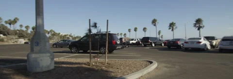 Left Side view of a Driving Plate: Car travels through a parking lot off Highway Stock Footage 59505570