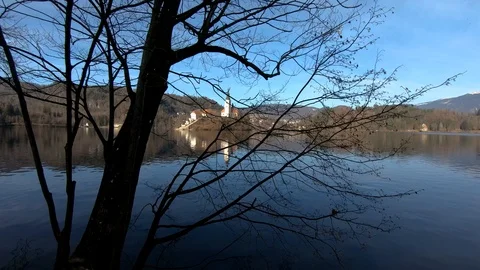 Left truck moving behind tree silhouette lake Bled island Video stock 123168767