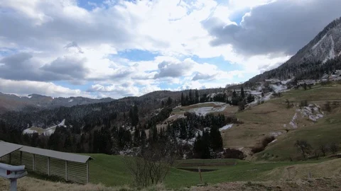 Left truck parallel moving Alpine settlement in hills Stock Footage 127796616