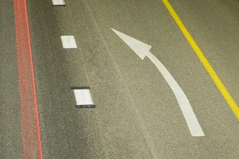Left turn arrow on the road between continuous and discontinuous. On the left Foto stock