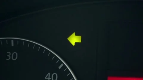 Left turn signal indicator lights up while driving on a dark road at night Stock Footage 335333819