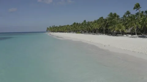 To the left is turquoise water and to the right is a beach with palm trees Stock Footage 140862802