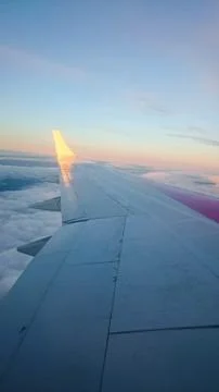 The left wing of a flying plane from the window above the clouds. Foto stock