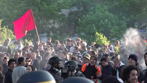 Left wing protests wave red flags during the May Day protests in Paris, Stock Footage 244789742
